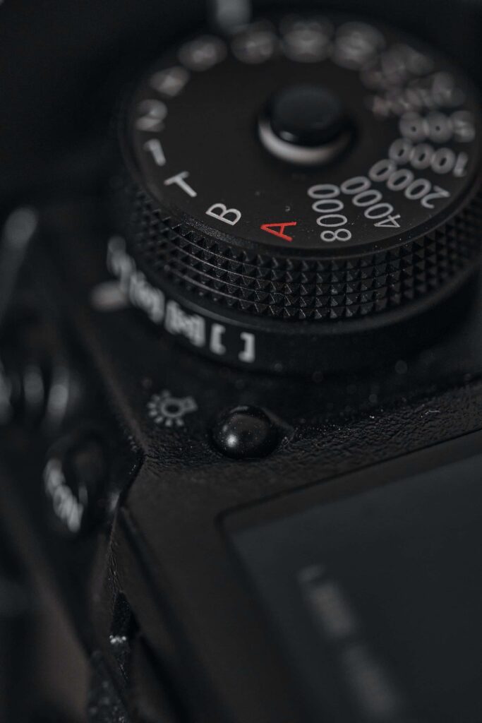 The shutter speed dial on a black Fujifilm X-H1 mirrorless camera with shutter speed settings ranging from Auto to 8000 written in white and red