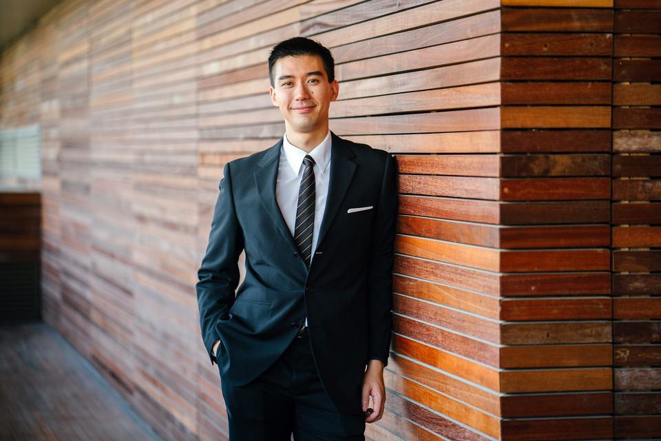 Man in suit leaning against the wall