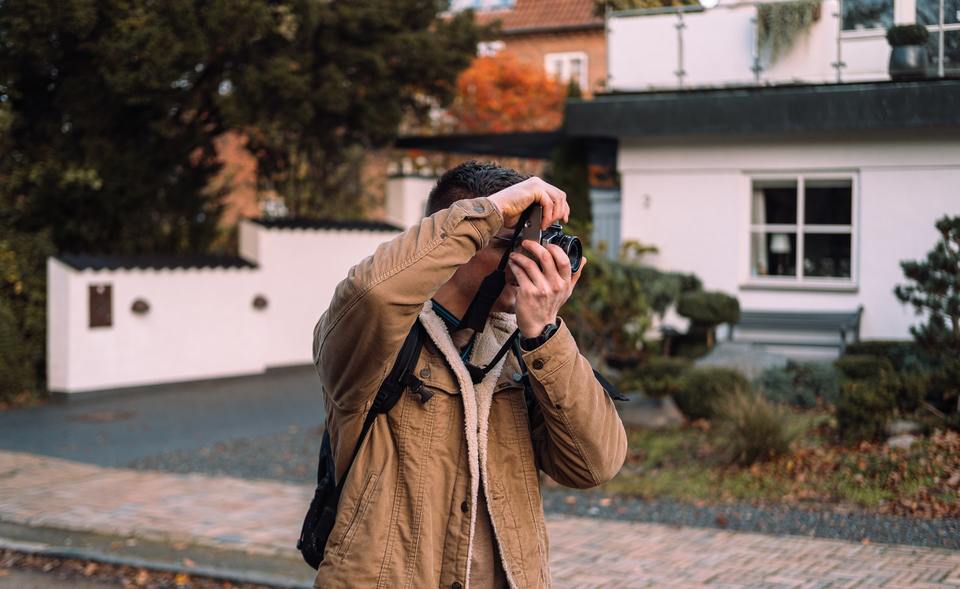 Man photographing house exterior