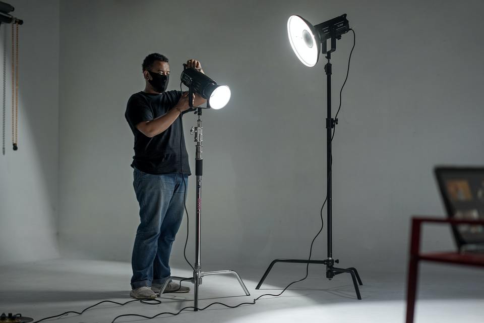 Man in black shirt fixing lighting gear
