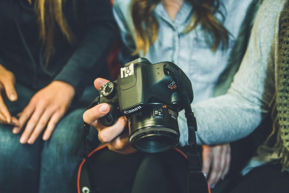 Photographer showing camera to other persons