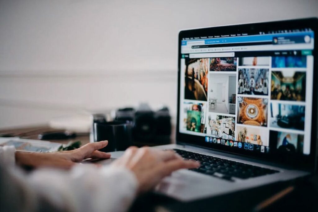 Person using a silver laptop while editing multiple video clips